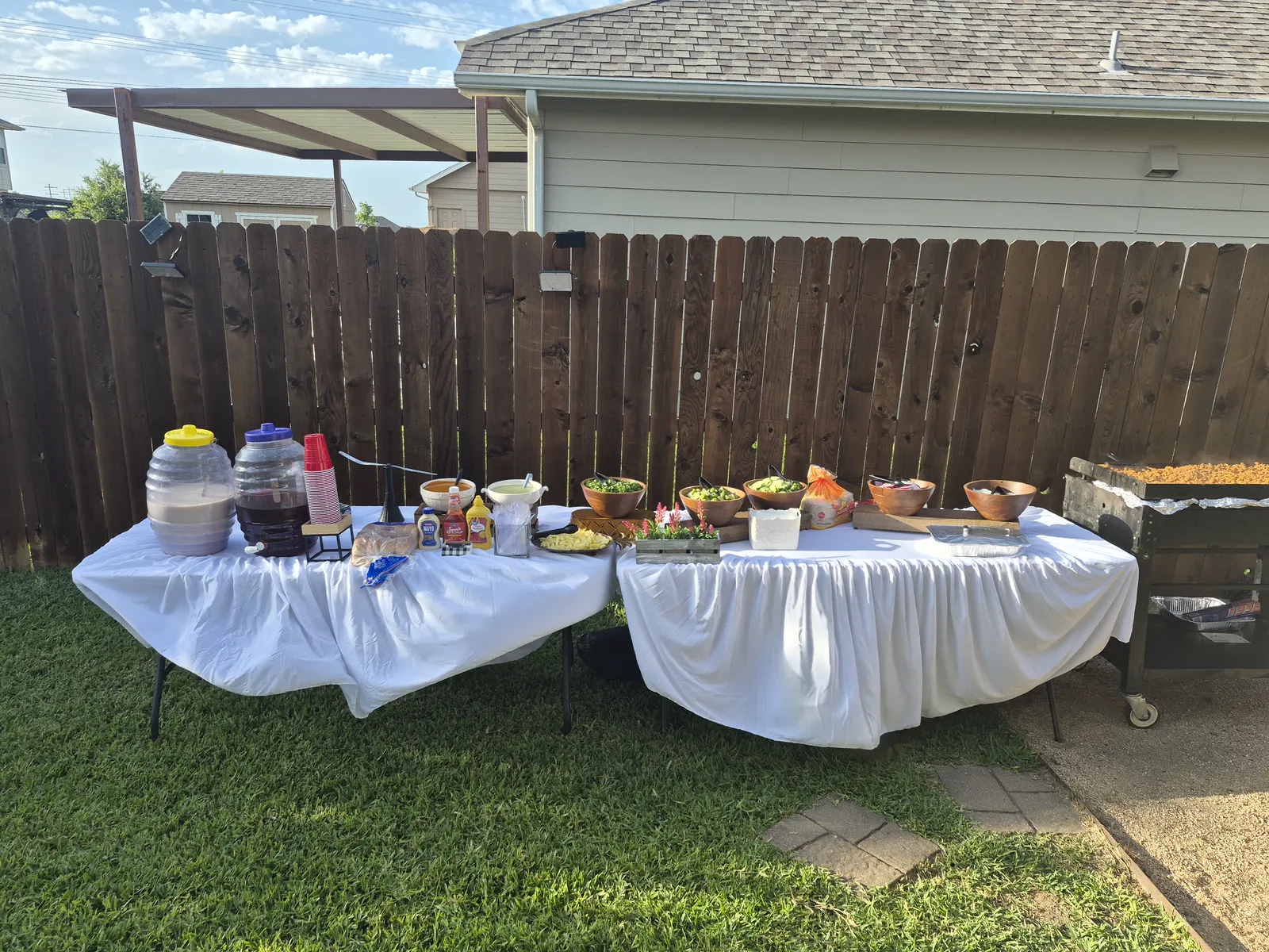 Antojitos Anthony's catering table with food, toppings, drinks, and grill